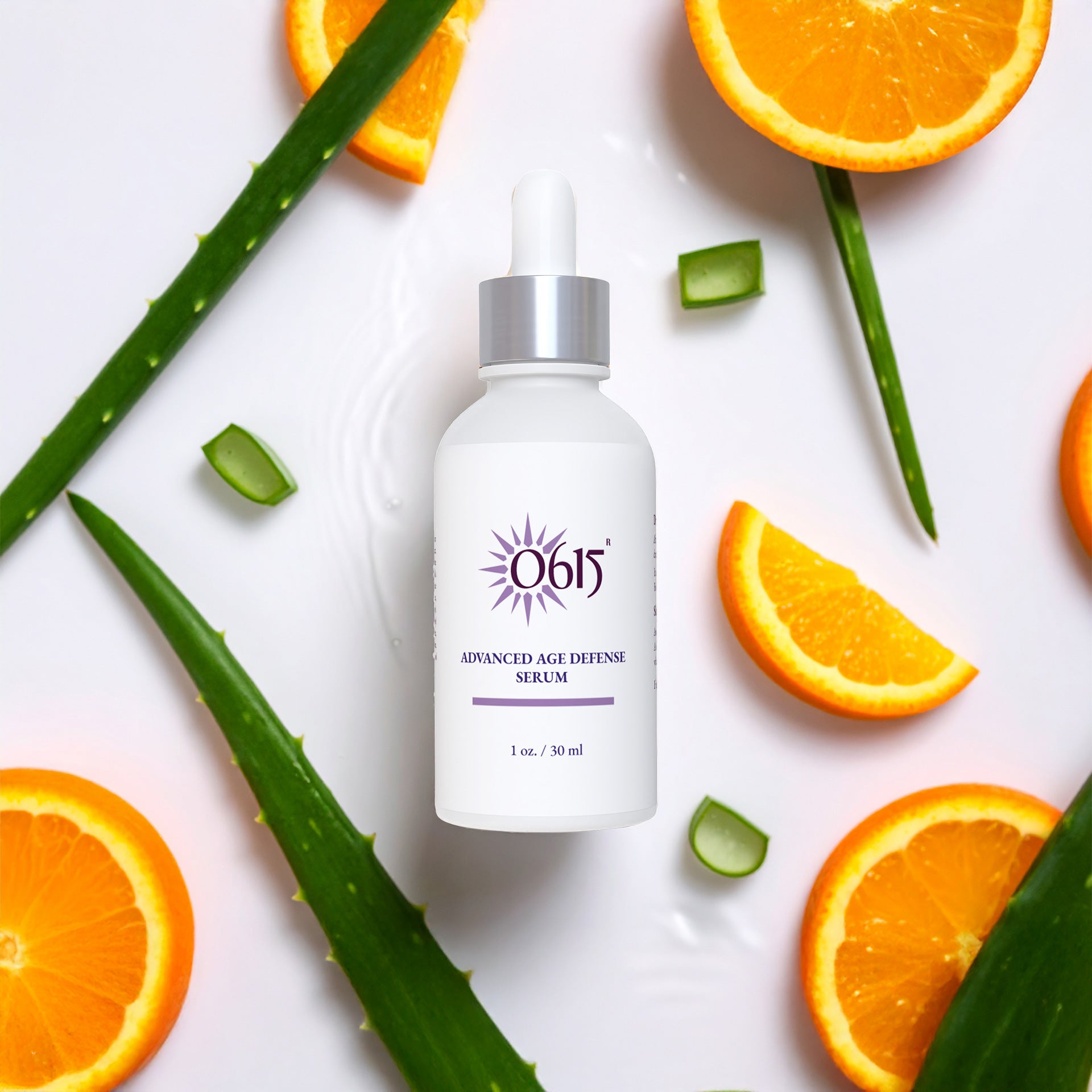 Advanced Age Defense Serum bottle with oranges and aloe vera leaves on a white background