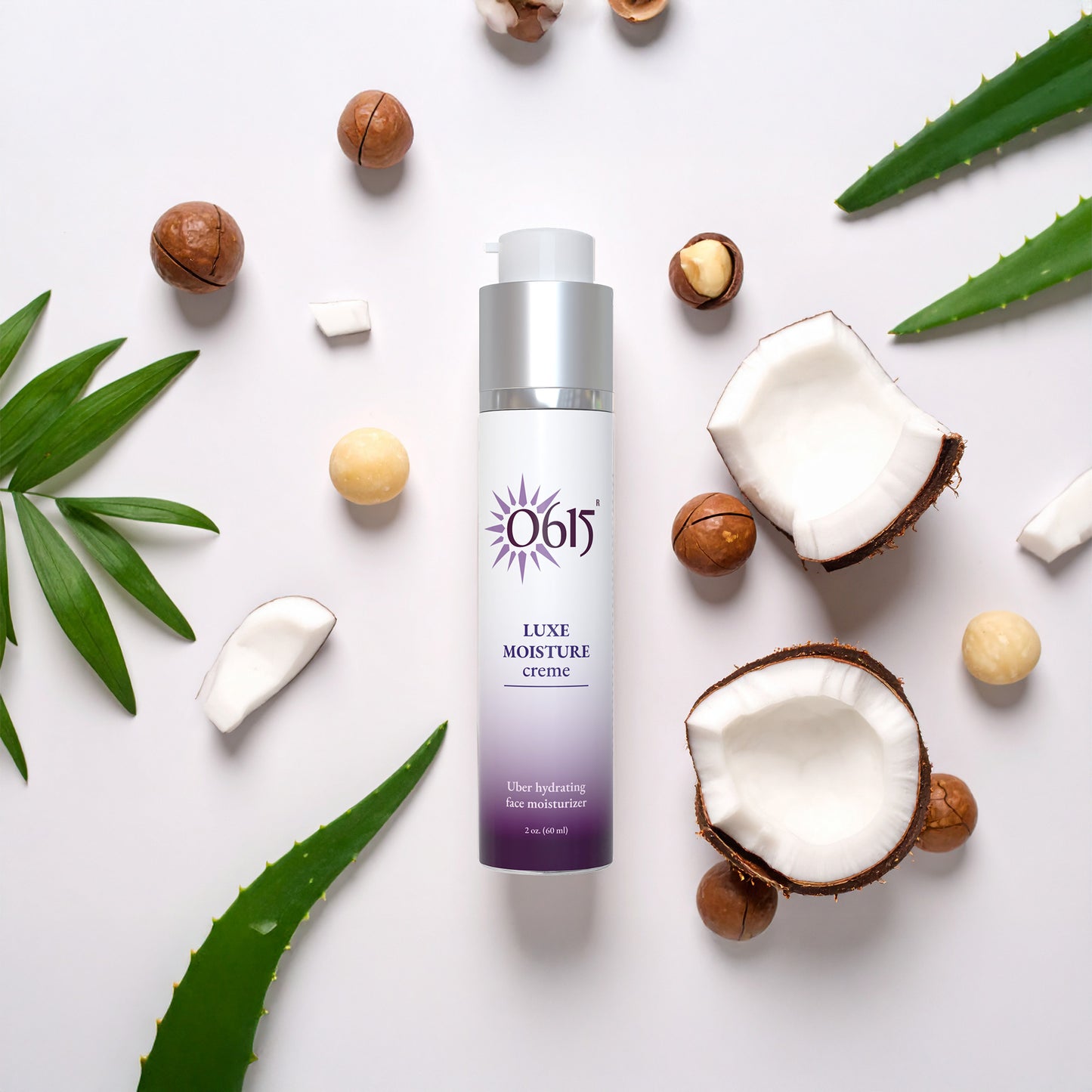 Luxe Moisture Crème bottle surrounded by coconuts, nuts, and aloe vera leaves on a white background